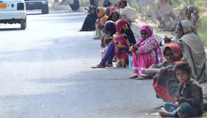 A child is seen looking at the camera along with other beggars sitting on the roadside at Wahduwah road on February 10, 2022 — APP.