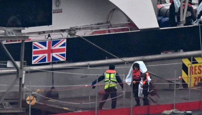 Migrants with children, some of the first in 2024 to be picked up at sea attempting to cross the English Channel from France, disembark from the UK Border Force Cutter Typhoon, at the Marina in Dover southeast England, on January 13, 2024.— AFP