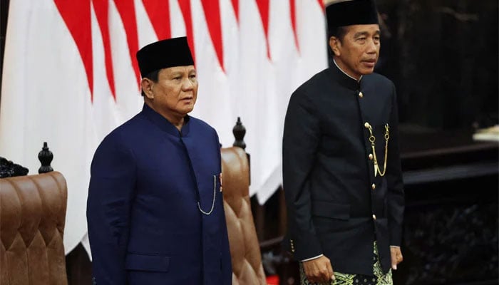 Indonesias new President Prabowo Subianto (left) and outgoing President Joko Widodo stand for the National anthem after the presidential inauguration, at the House of Representatives building in Jakarta, Indonesia October 20, 2024. — Reuters