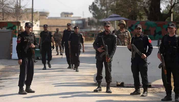 Pakistani soldiers and policemen stand guard. — AFP/File