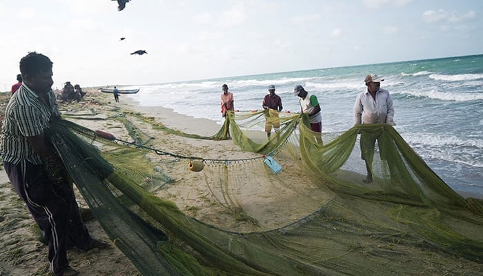 The representational image shows a group of local fishermen attempting to clean an empty fishing net that has just been pulled to shore in Mannar, Sri Lanka, August 17, 2022. — Reuters