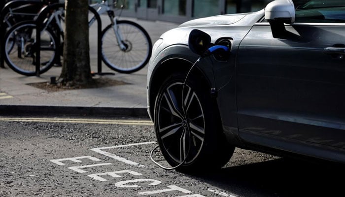 An EV standing at a charging station can be seen. — AFP/File