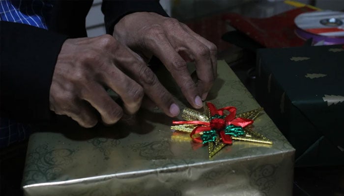 A person wraps a present for a customer adding some festive detailing on it. — Geo.tv/Rabia Mushtaq/File