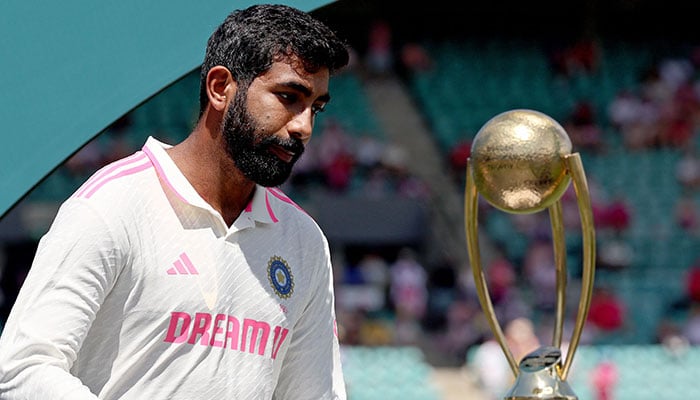 Indias Jasprit Bumrah reacts as he walks past the trophy during an official ceremony after the fifth cricket Test match between Australia and India at The SCG in Sydney on January 5, 2025. —AFP