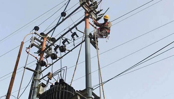 A representational image showing a worker carrying out inspection and repair works on a transformer. — AFP/File