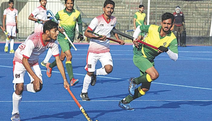 Players of Army-B and MPCL vie for the ball during their National Junior Hockey Championship match at the National Hockey Stadium on Monday.—APP/File