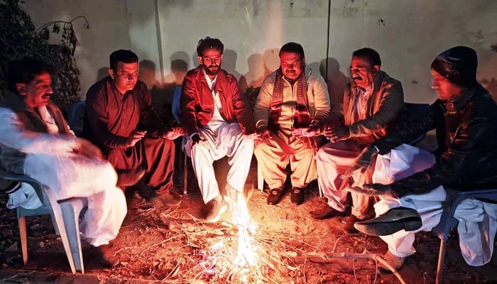 A representational image of people warming their hands on bonfire to save themselves from cold waves during the winter season, in Larkana on December 22, 2024. — PPI