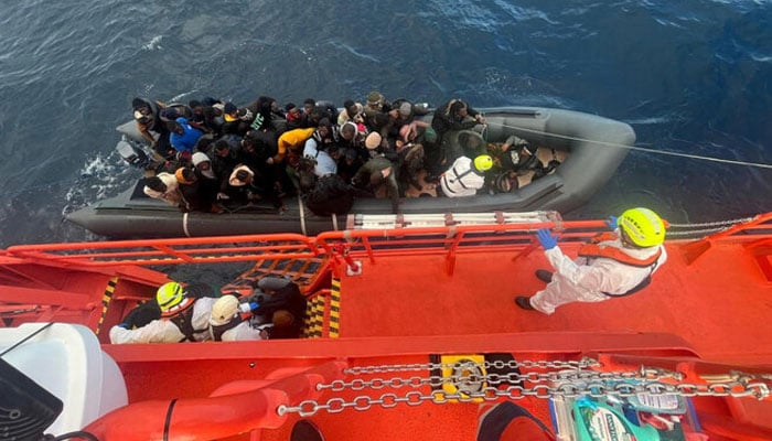 Spanish coast guards wearing white suits work on a rescue operation as they tow a rubber boat carrying migrants, including a newborn baby, off the Canary Island of Lanzarote, in Spain, in this handout picture obtained on Jan. 8, 2025. —Reuters