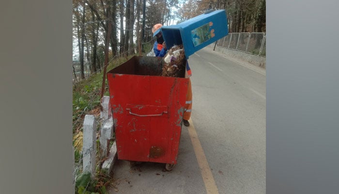 A representational image of an employee disposes garbage in Islamabad. — Facebook@RawalpindiWasteManagementCompany/File