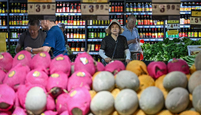 People buying goods in a supermarket. — AFP/File