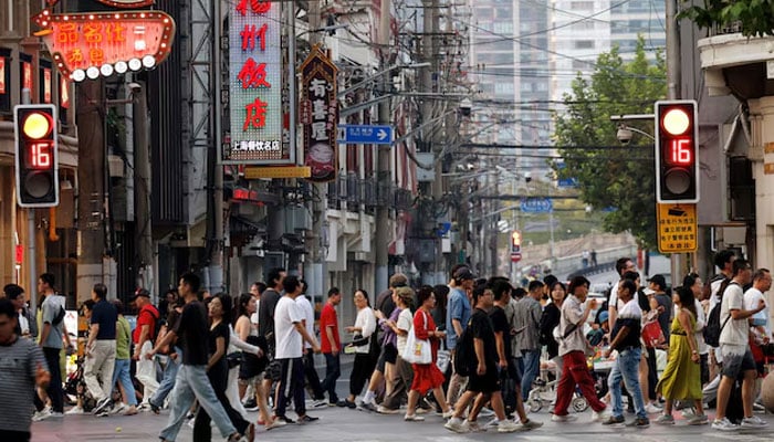 People walk past a lane lined up with restaurants, at a shopping area in Shanghai, China, on September 28, 2024. — Reuters