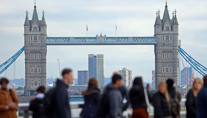 People walk over London Bridge looking at a view of Tower Bridge in the City of London financial district in London, Britain, October 25, 2023. — Reuters