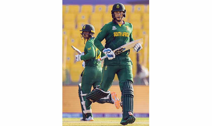 South Africa’s Quinton de Kock (L) with teammate Rassie van der Dussen run between the wickets during their match against Bangladesh