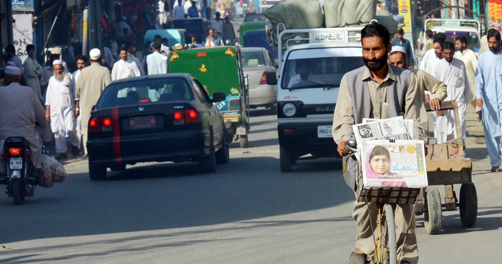 A vendor carrying morning newspapers in Mingora.  -- Photo by A Majeed / AFP