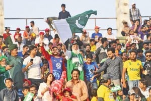 Pakistani cricket fans wave national flag at the National Cricket Stadium during the Pakistan Super League final match between Peshawar Zalmi and Islamabad United in Karachi on March 25, 2018. 