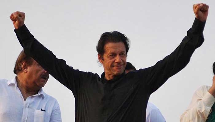 Imran Khan holding his arms in the air in triumph in this Online file photo.