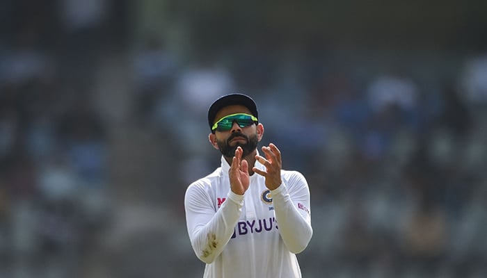 Indias captain Virat Kohli gestures towards the audience during the second day of the second Test cricket match between India and New Zealand at the Wankhede Stadium in Mumbai on December 4, 2021. — AFP