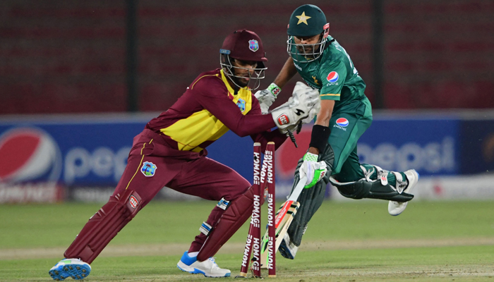 West Indies captain Nicholas Pooran (L) successfully runs out Pakistan cricket captain Babar Azam (R) during the second Twenty20 international cricket match between Pakistan and West Indies at the National Stadium in Karachi on December 14, 2021. — Photo by Asif Hassan/AFP