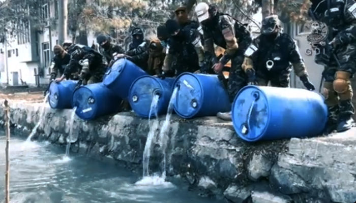 Screen grab from video footage released by the General Directorate of Intelligence (GDI) showing its agents pouring alcohol stored in barrels into a canal in Kabul. — Twitter/GDI