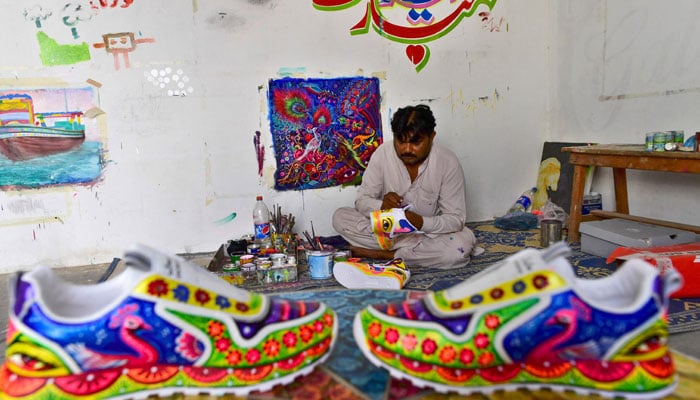 In this picture taken on February 28, 2022, truck artist Haider Ali works on a pair of sneakers at his workshop in Karachi. — AFP/File