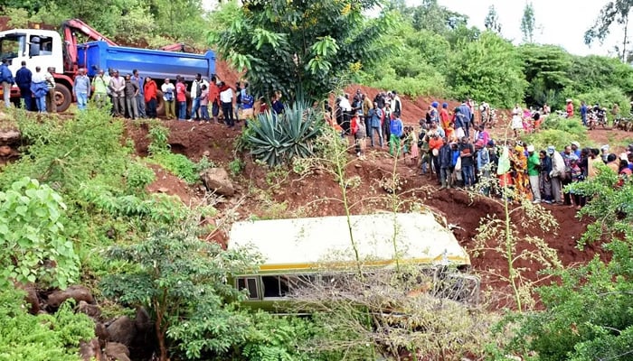A file photo shows people looking at the wreckage of a bus that had been transporting primary school pupils from Arusha to Karatu in Tanzania before plunging into a gorge, killing at least 29 children, two teachers and the driver, on May 6, 2017. — AFP