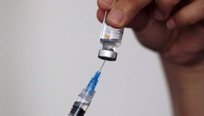 Image of a needle and a vial of vaccine. — AFP/file