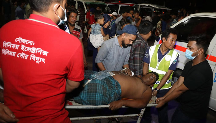 Rescue workers and civilians carry an injured victim to a hospital in Chittagong, Bangladesh, after a massive fire broke out at a local container storage center. Photo: AFP