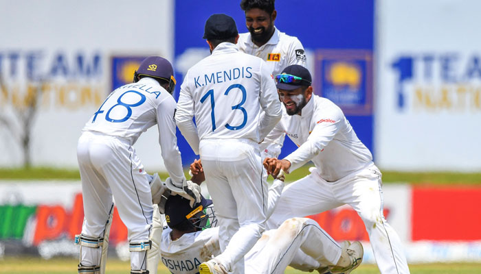 Sri Lanka’s Oshada Fernando (C) celebrates with his captain Dimuth Karunaratne (R) after taking the wicket of Pakistan’s Mohammad Nawaz during the second day of the first cricket Test match between Sri Lanka and Pakistan at the Galle International Cricket Stadium. Photo: AFP