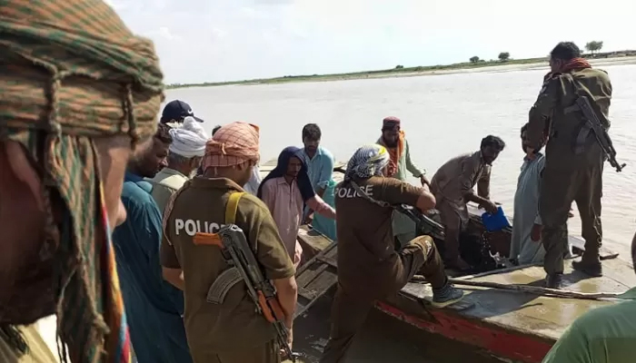 Policemen and villagers prepare to search for the victims drowned in the Indus River after an overcrowded boat carrying a wedding party capsized on the outskirts of Sadiqabad town, on July 18, 2022 — AFP