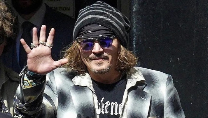 Johnny Depp gets mobbed by fans as he steps out of a restaurant in Paris