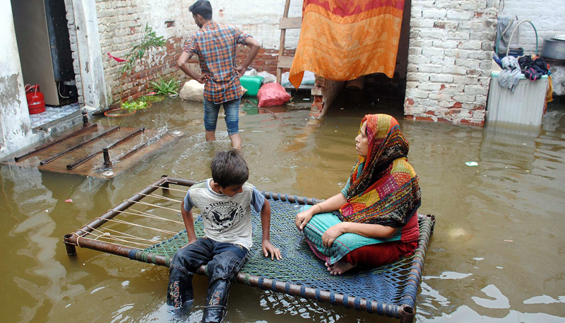 Rain affected people facing problems due to rainwater inundated in their house at Mehar Ali Society after heavy rains, in the city. —Online