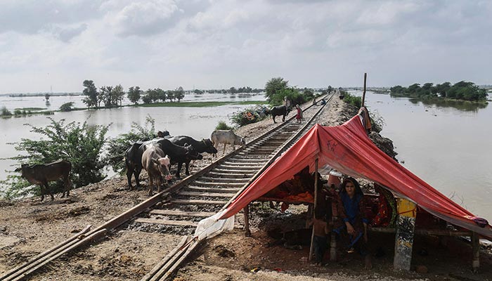 A flood affected family sits inside a makeshift tent next to a railway track after heavy monsoon rains in Jacobabad of Sindh province, southern Pakistan on August 26, 2022. — AFP/File