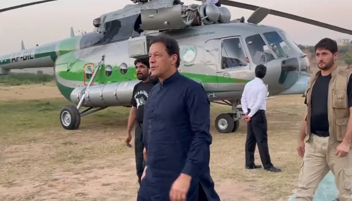 PTI Chairman and former prime minister Imran Khan steps down from his helicopter which faced technical issues ahead of its emergency landing in a village at the outskirts of Adiala Town in Rawalpindi. — PTI