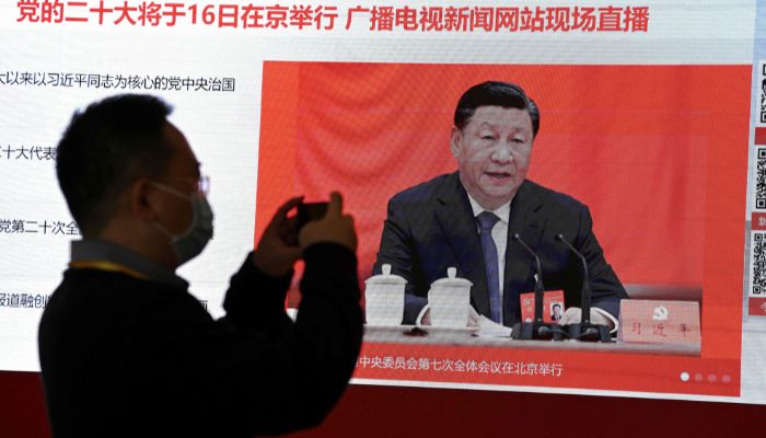 A journalist takes a photo of a screen showing Chinese President Xi Jinping at the press centre ahead of Chinas 20th Communist Party Congress in Beijing on October 15, 2022.— Reuters