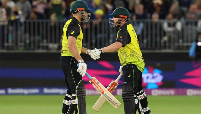 Australia’s Aaron Finch (R) and Marcus Stoinis bump gloves during the ICC men’s T20 World Cup 2022 cricket match between Australia and Sri Lanka at Perth Stadium on October 25, 2022. — AFP