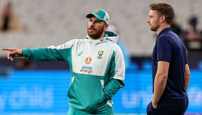 Australia´s Aaron Finch (L) chats to England´s Jos Buttler prior to the ICC men´s Twenty20 World Cup 2022 cricket match between Australia and England at Melbourne Cricket Ground (MCG) on October 28, 2022, in Melbourne.— AFP