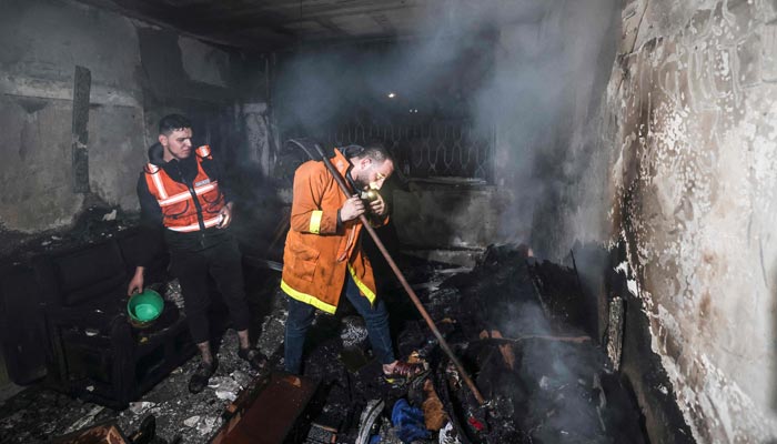 Palestinian firefighters extinguish flames in an apartment ravaged by fire in the Jabalia refugee camp in the northern Gaza strip, on November 17, 2022. — AFP