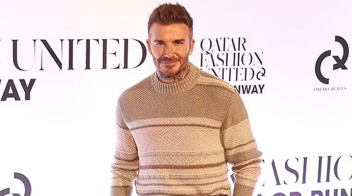 David Beckham cuts a trendy figure in a brown sweater at Qatar