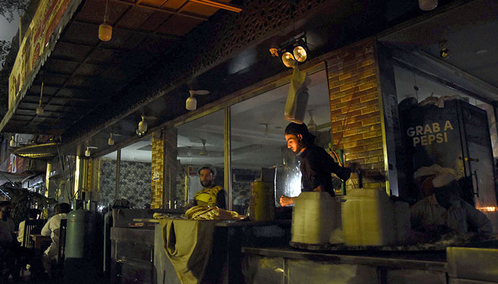 Workers busy preparing bread outside a local restaurant at sector G-7 during load shedding in Islamabad on July 14, 2022. — Online/File