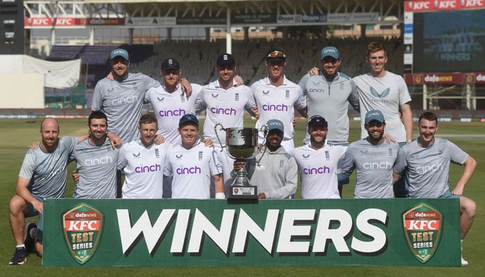 Englands cricketers pose with the trophy after winning the test series at the end of fourth day of third test match between Pakistan and England at the National Stadium in Karachi on December 20, 2022. — AFP