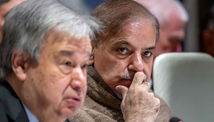 Pakistan Prime Minister Shehbaz Sharif (R) listen to UN Secretary-General Antonio Guterres (L) delivering a speech at the start of a Pakistan´s Resilience to Climate Change conference in Geneva on January 9, 2023. — AFP