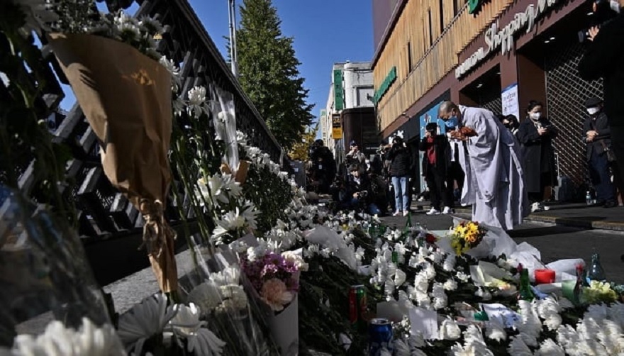 A Buddhist nun prays in tribute to those who were killed, at a makeshift memorial outside a subway station in the district of Itaewon in Seoul on October 31, 2022, two days after a deadly Halloween crush in the area. — AFP