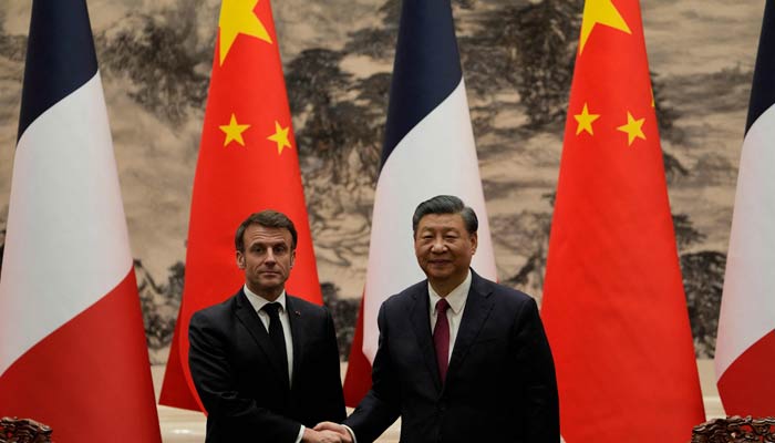 French President Emmanuel Macron (L) shakes hands with Chinese President Xi Jinping during a joint meeting of the press at the Great Hall of the People in Beijing on April 6, 2023. — AFP