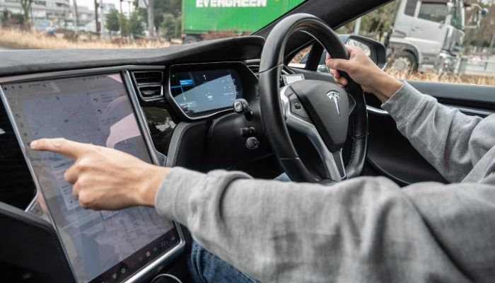This photo taken on January 27, 2023 shows Atsushi Ikeda, the founder and vice president of a Japanese club for Tesla owners, operating a touchscreen display on the dashboard of his Tesla Model S in Tokyo.— AFP