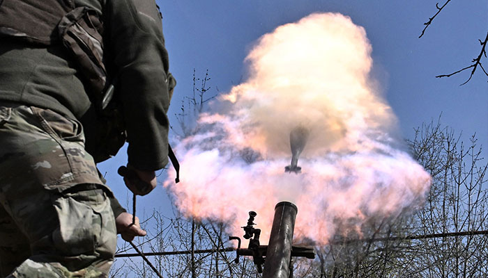 A Belarusian volunteer soldier from the Kastus Kalinouski regiment, a regiment made up of Belarusian opposition volunteers formed to defend Ukraine, fires a 120mm mortar round at a front line position near Bakhmut in the Donetsk region, on April 9, 2023, amid the Russian invasion of Ukraine. —AFP