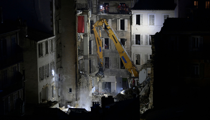 An excavator moves rubble at rue Tivoli after a building collapsed in the same street, in Marseille, southern France, on April 9, 2023. — AFP