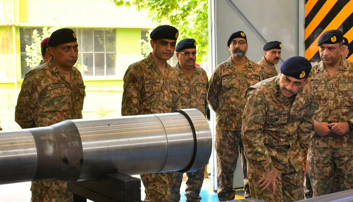 Army chief Gen Munir takes a look at a missile at HIT. — ISPR