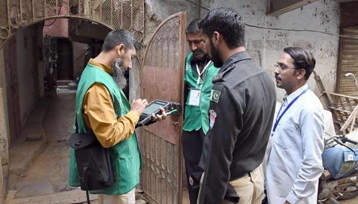An official from the Pakistan Bureau of Statistics uses a digital device to collect information from a resident during door-to-door the first-ever digital national census in Karachis Old City area on March 3, 2023. — Online
