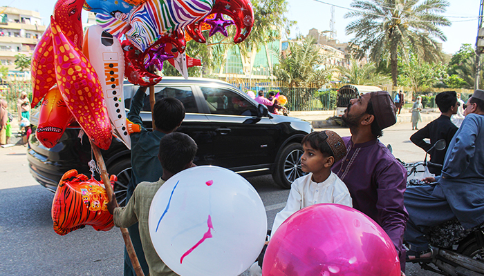Children buy balloons after Eid ul Fitr prayers in Karachi's Saddar area, on April 22, 2023. — Hassaan Ahmed