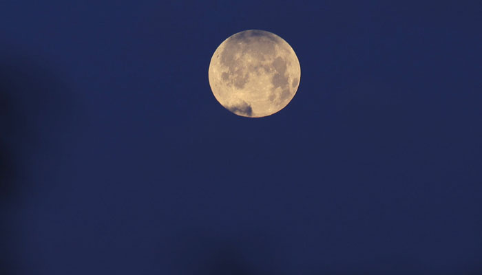 The full moon rises over Gaza City early on April 6, 2023. — AFP